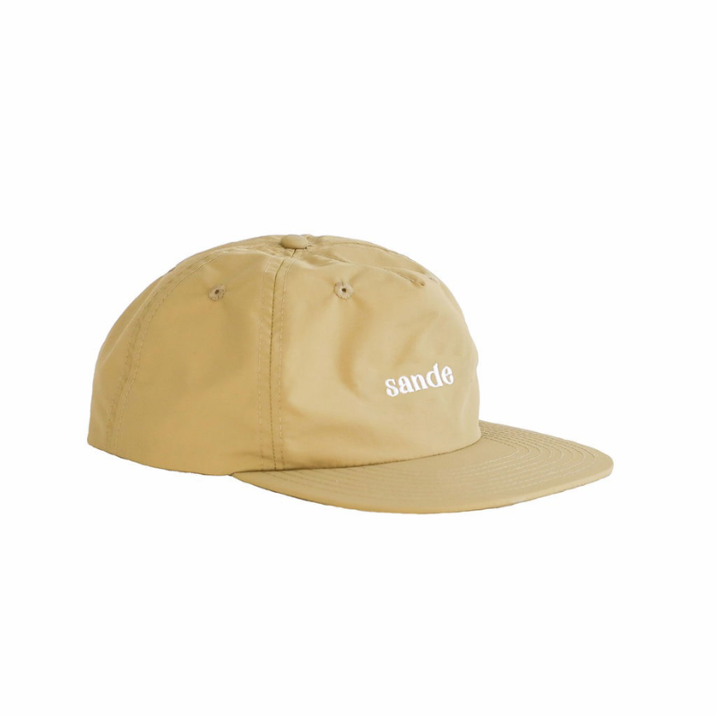A beige cap made from waterproof nylon fabric, shown from the side. The cap features the Sande logo embroidered in white on the front.