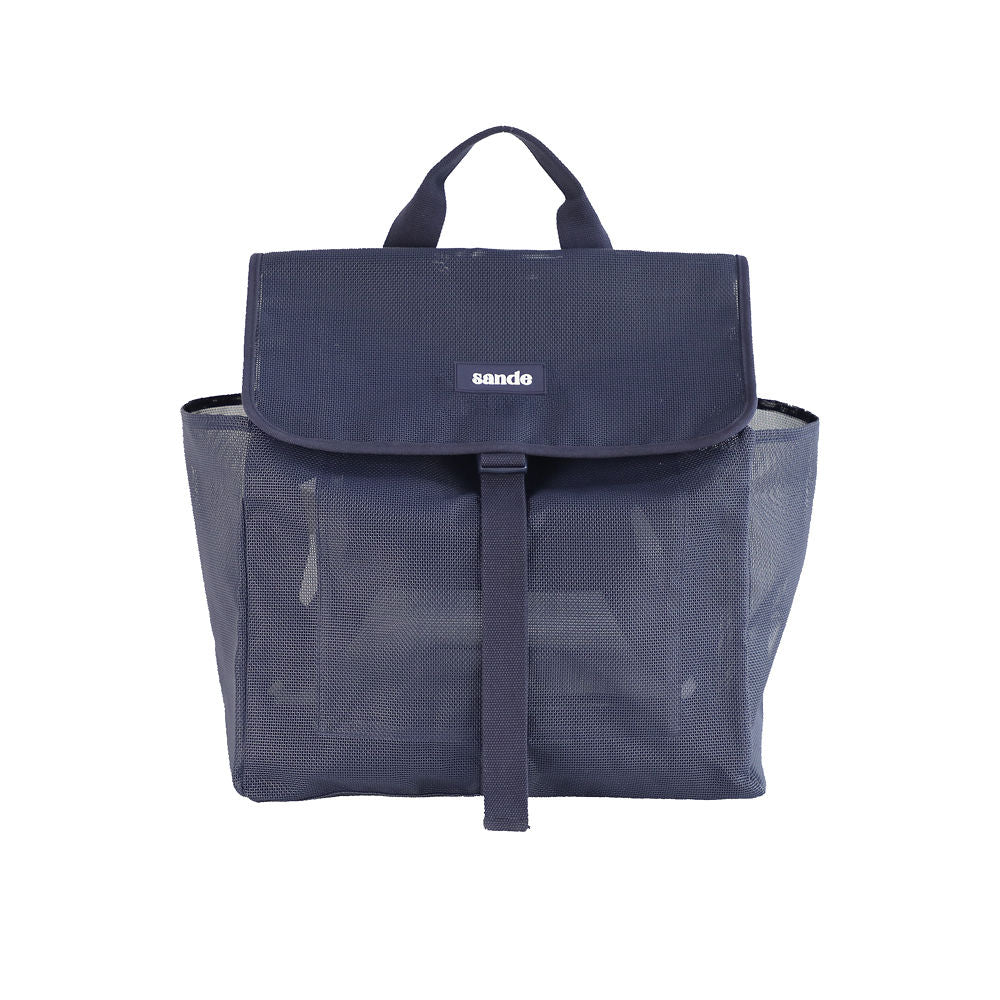 Studio image of the Sande Beach Hauler mesh backpack in Deep Sea Navy, showing the front view. Features include a top carry handle, two side mesh pockets, a flap with a clip for security, and a silicone label with the Sande logo in white.