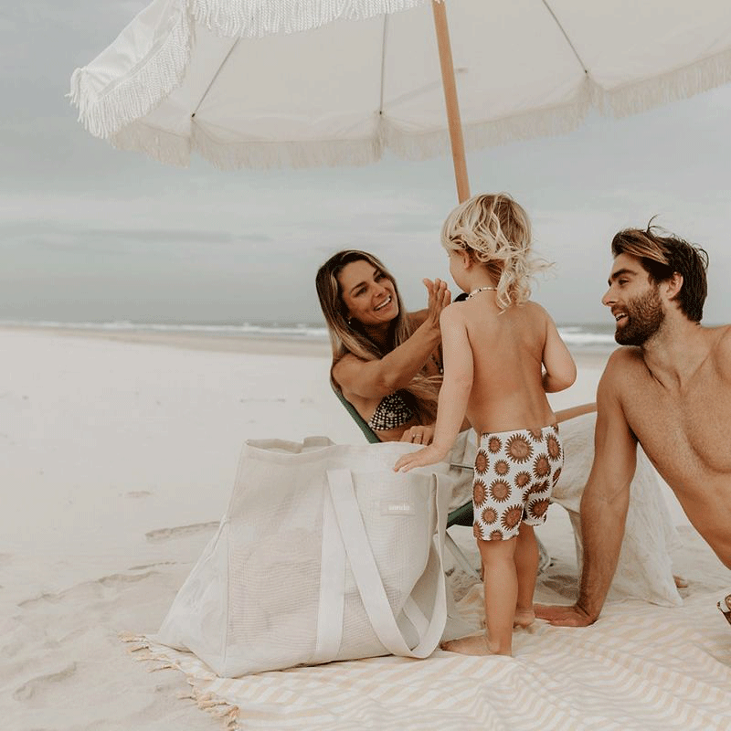 Family enjoying a day at the beach with their Sande™ Beach Hauler in Sand, highlighting the bag&