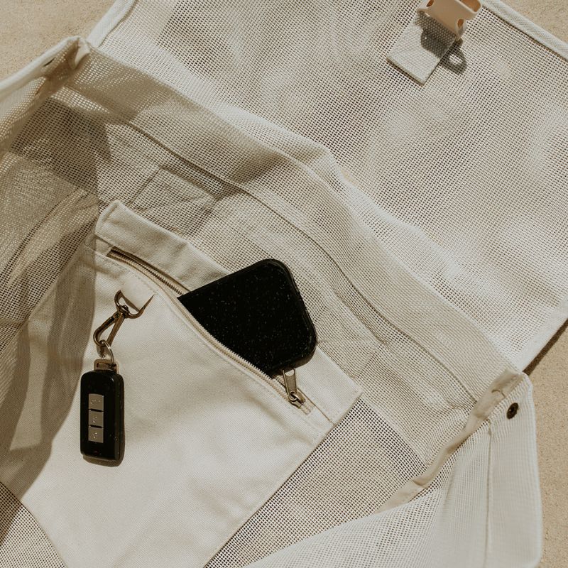 Close-up of the internal secure canvas pocket and key clip in the Sande Beach Hauler mesh backpack, designed to keep valuables safe.