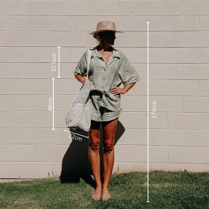 A Sande Beach Hauler Mini mesh beach bag packed with beach essentials such as towels, sunscreen, hats, and water bottles showcasing the spacious interior and functionality of this large beach bag. Perfect for family outings and beach days.