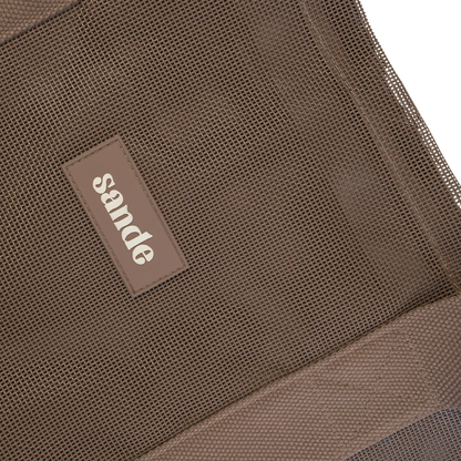 Close-up image of the Sande™ Beach Hauler oversized mesh bag in Espresso Brown, highlighting the durable mesh fabric, thick cotton straps, and silicone Sande logo. Perfect for carrying beach essentials on family beach days, market trips, and outdoor adventures.
