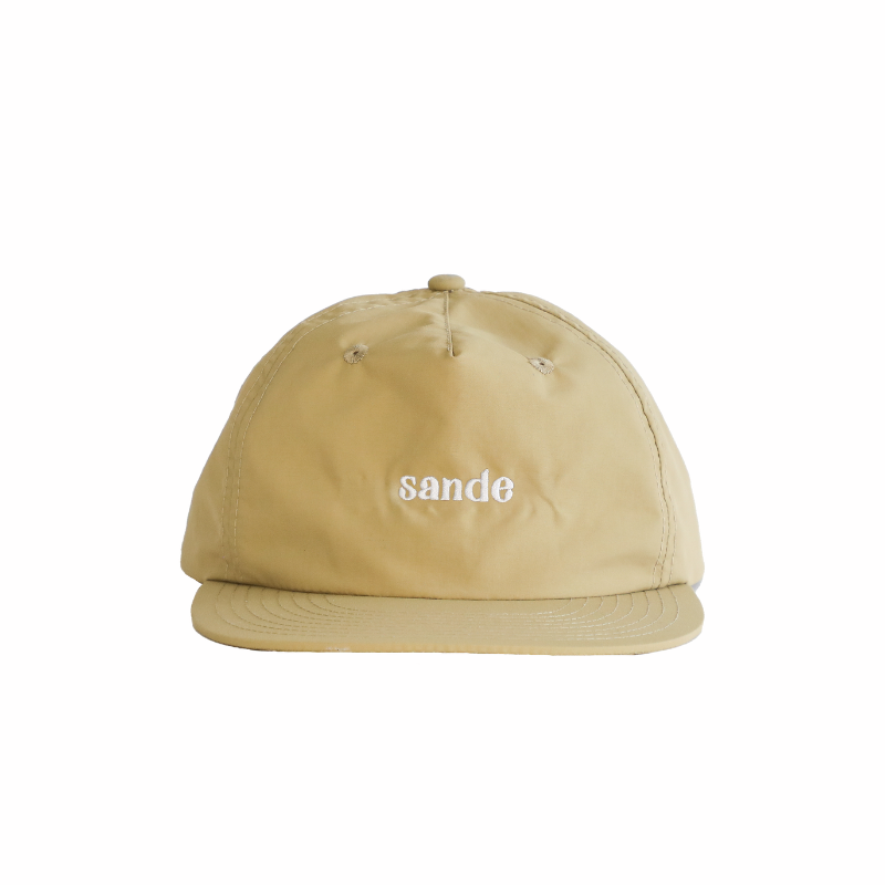 A beige cap made from waterproof nylon fabric, shown from the front. The cap features the Sande logo embroidered in white on the front.