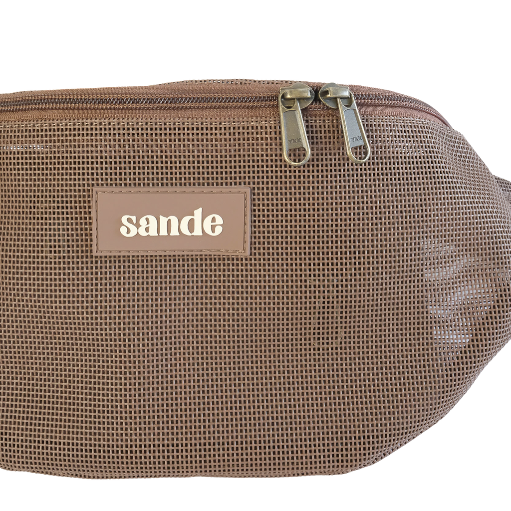 Close up studio detail of the Sande Essentials Crossbody Bag in Espresso, highlighting the espresso mesh fabric, silicone Sande logo and dual YKK brass zipper pulls on the espresso brown zip.