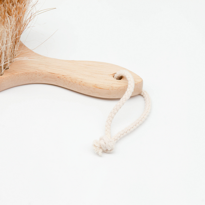 Sande™ Sand Brush / Surf Brush made from sustainable rubberwood, featuring a wooden handle and a hanging cotton cord leash. Perfect for swiftly sweeping wet or dry sand from kids, adults, beach toys, surfboards, pets, car upholstery, and carpets.
