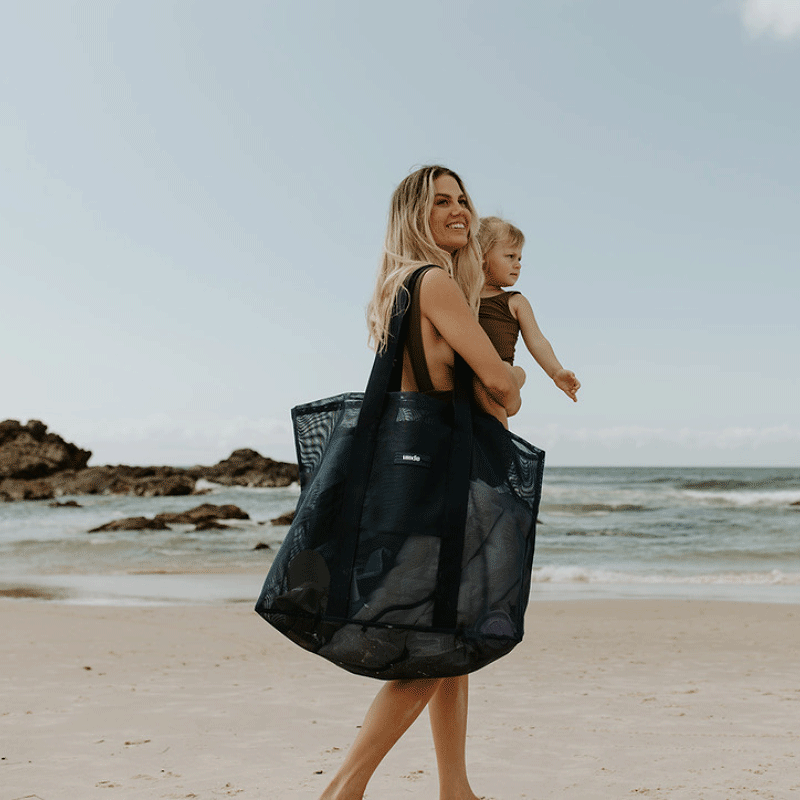 Oversized Sande Beach Hauler mesh beach bag in Deep Sea Navy, displayed in a studio setting. Positioned at a 45¬∞ angle to highlight the mesh detail, thick cotton straps, and silicone Sande  logo. Set against a white background.