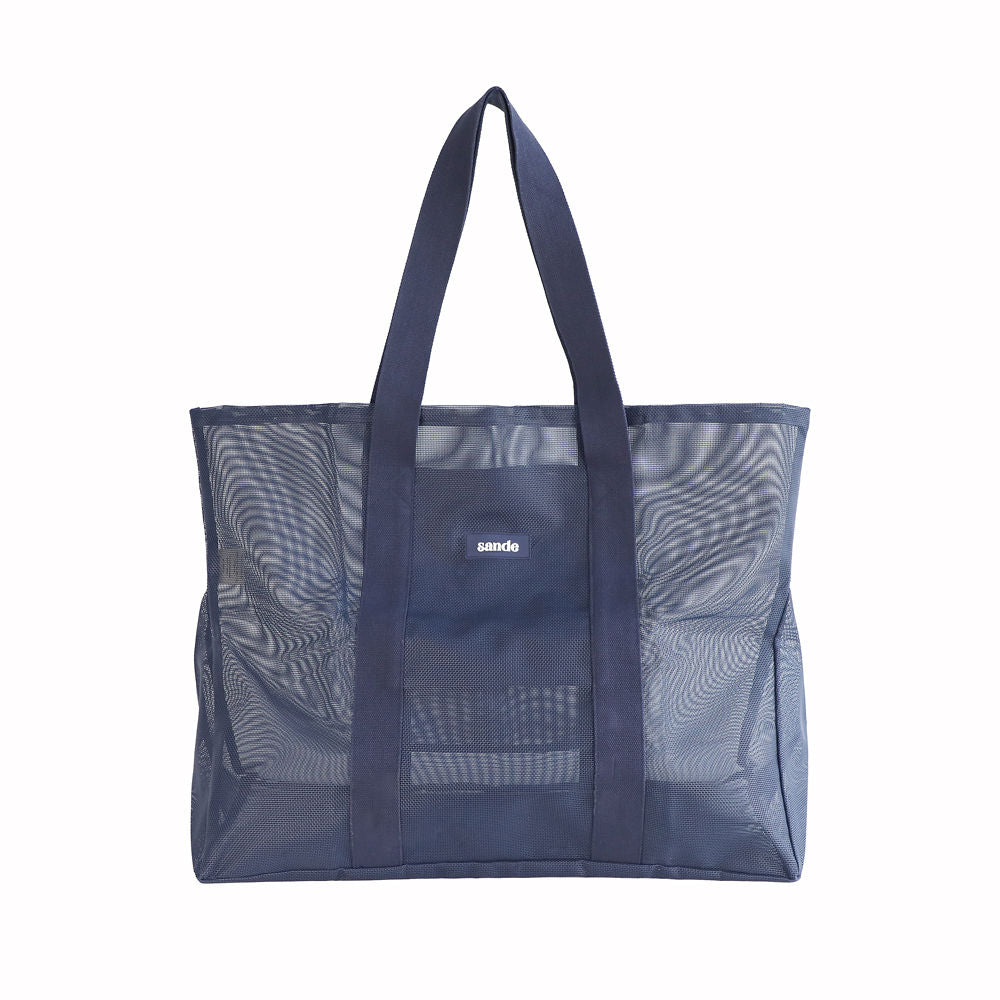 Oversized Sande Beach Hauler mesh beach bag in Deep Sea Navy, displayed in a studio setting. Shown front-on to highlight the mesh detail, thick cotton straps, and silicone Sande  logo. Set against a white background.
