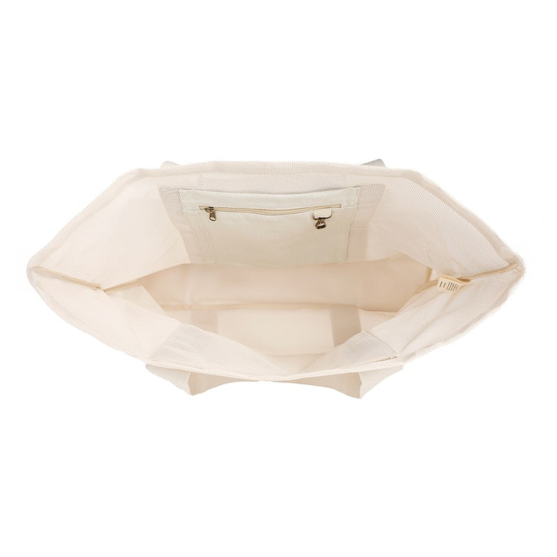 Close-up product photo of the internal pockets of the Sande Beach Hauler mesh beach bag on a white background. This image highlights the bag&